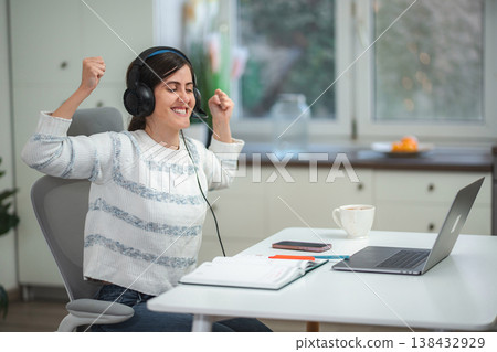 Happy woman celebrating success while working from home Happy woman celebrating success while working from home 138432929