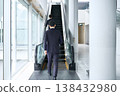 一位商務人士在辦公大樓的自動扶梯上行走,這是他的背影。 一位商務人士在辦公大樓的自動扶梯上行走,這是他的背影。 138432980