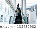 辦公大樓裡,商務人士和職業婦女的背影正沿著自動扶梯向上移動。 辦公大樓裡,商務人士和職業婦女的背影正沿著自動扶梯向上移動。 138432982