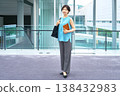 一張全身照,一位自信的日本女商人站在現代化的辦公大樓裡,手裡拿著筆記本。 一張全身照,一位自信的日本女商人站在現代化的辦公大樓裡,手裡拿著筆記本。 138432983