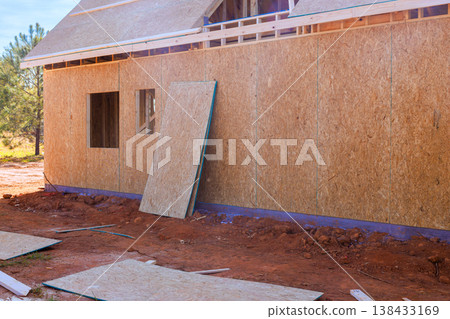 Workers are laying down wood plywood panels for house under construction during build process Workers are laying down wood plywood panels for house under construction during build process 138433169