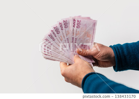 Man Holding Turkish Lira Banknotes Fanned in Hand, Cash Money Concept on White Background Man Holding Turkish Lira Banknotes Fanned in Hand, Cash Money Concept on White Background 138433170