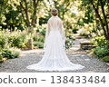 A bride walking through the garden, her back view in a lace train dress. 138433484