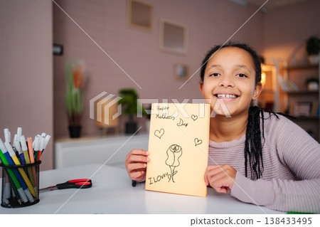 Young girl holding handmade card for Mother's Day 138433495