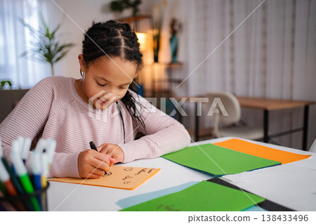 Young girl drawing on paper at home desk 138433496