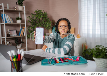 Student girl showing smartphone with blank screen for app promotion Student girl showing smartphone with blank screen for app promotion 138433508