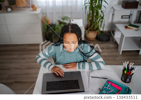 Young girl learning online from home using laptop Young girl learning online from home using laptop 138433511