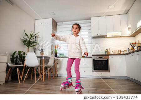 Girl rollerblading in kitchen at home having fun Girl rollerblading in kitchen at home having fun 138433774