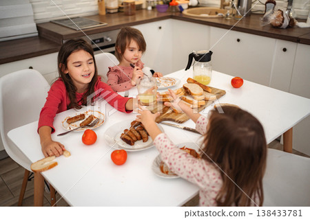 Children eating breakfast together at kitchen table Children eating breakfast together at kitchen table 138433781