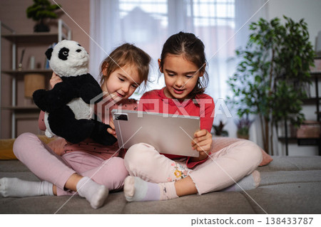 Young girls enjoying digital learning on a tablet at home Young girls enjoying digital learning on a tablet at home 138433787