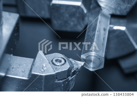 High-precision CNC lathe machine cutting a hexagon metal shaft for industrial component manufacturing. High-precision CNC lathe machine cutting a hexagon metal shaft for industrial component manufacturing. 138433804
