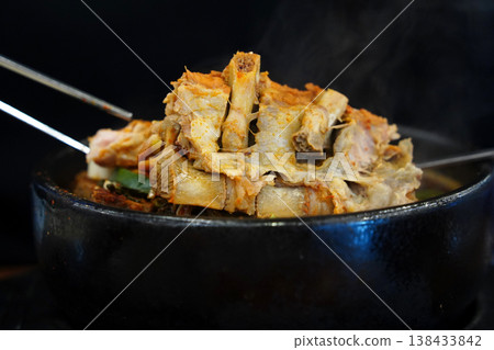 Hot Korean pork back bone stew (Haejangguk) with steam in a black earthenware pot (Ttukbaegi) Hot Korean pork back bone stew (Haejangguk) with steam in a black earthenware pot (Ttukbaegi) 138433842