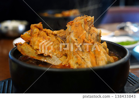 Hot Korean pork back bone stew (Haejangguk) with steam in a black earthenware pot (Ttukbaegi) Hot Korean pork back bone stew (Haejangguk) with steam in a black earthenware pot (Ttukbaegi) 138433843