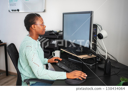 Black woman working from home using computer and keyboard Black woman working from home using computer and keyboard 138434064