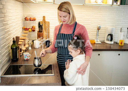 Mother and daughter cooking together in the kitchen Mother and daughter cooking together in the kitchen 138434073