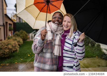 Diverse adult women friends enjoying a rainy autumn day Diverse adult women friends enjoying a rainy autumn day 138434084