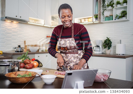 Woman cooking fresh ingredients following recipe on digital tablet Woman cooking fresh ingredients following recipe on digital tablet 138434093