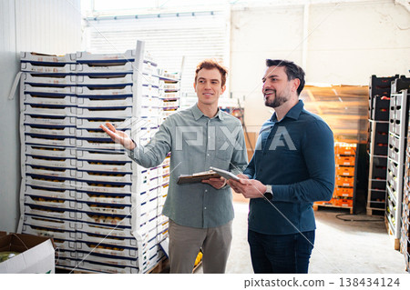 Warehouse workers discussing inventory holding tablet and clipboard Warehouse workers discussing inventory holding tablet and clipboard 138434124