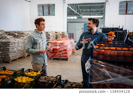 Business partners discussing fresh produce supply chain in warehouse 138434128