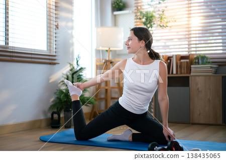 Young woman doing yoga at home, Twisting lunge quad stretch Young woman doing yoga at home, Twisting lunge quad stretch 138435065