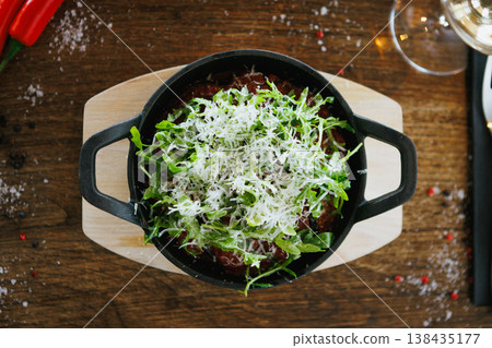 Creamy tomato pasta in cast iron skillet with arugula 138435177