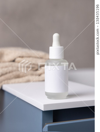 Dropper bottle with blank label near bath towels in beige bathroom, cosmetic mockup Dropper bottle with blank label near bath towels in beige bathroom, cosmetic mockup 138435196