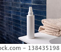 White pump cosmetic bottle near beige bath towel in dark blue bathroom, cosmetic mockup 138435198