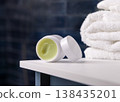 Opened handmade lip balm jar in blue bathroom with towel. Blank lid cosmetic mockup 138435201