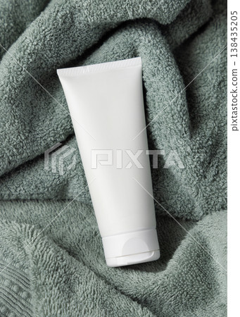 White blank cream tube on sage green bath towel top view, unbranded cosmetic mockup White blank cream tube on sage green bath towel top view, unbranded cosmetic mockup 138435205