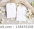 Blank vertical gift tags mockup with white spring flowers and driftwood on light stone, label design 138435208