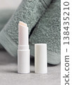 White opened lip balm stick mockup with a lid near light green bath towel, unbranded packaging 138435210