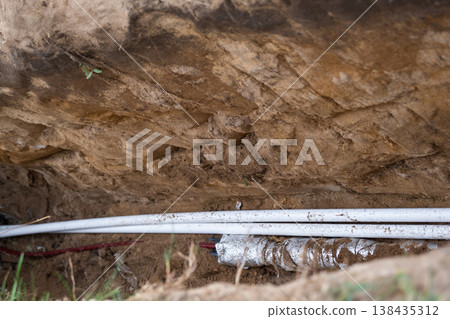 Insulated pipeline in ground trench, water supply line, outdoor utility, site groundwork, pipe protection, residential plumbing, heat insulation channel. 138435312