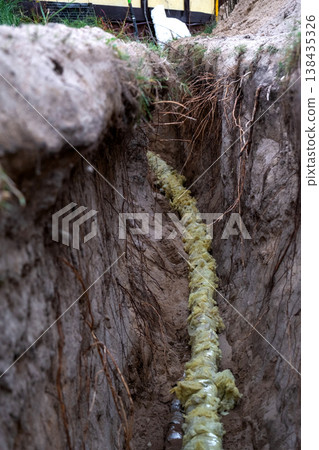 Water pipeline with insulation, placed in trench, groundwork installation, plumbing utility, protection, repair, site maintenance, outdoor construction, coverage, engineer. Water pipeline with insulation, placed in trench, groundwork installation, plumbing utility, protection, repair, site maintenance, outdoor construction, coverage, engineer. 138435326