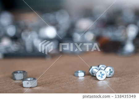 Close-up of metal nuts and washers, essential hardware for repair, industrial assembly, construction and production, used in installation and maintenance. Close-up of metal nuts and washers, essential hardware for repair, industrial assembly, construction and production, used in installation and maintenance. 138435349