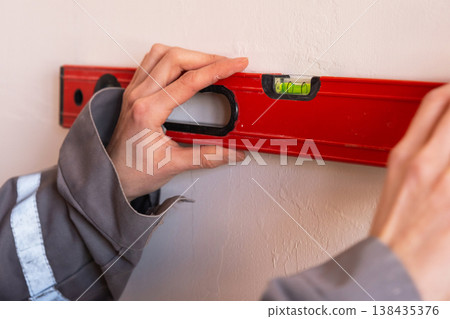 Spirit level marking for interior work, precision line drawing, wall preparation for construction installation, measurement and alignment guide. Spirit level marking for interior work, precision line drawing, wall preparation for construction installation, measurement and alignment guide. 138435376