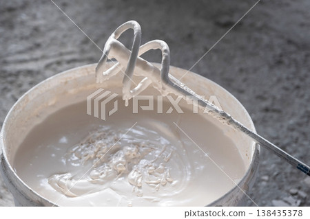 Preparation of plaster compound with electric mixer, uniform putty mixing, renovation stage, repair work, tools for construction finishing. Preparation of plaster compound with electric mixer, uniform putty mixing, renovation stage, repair work, tools for construction finishing. 138435378