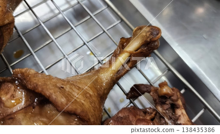Crispy Golden Brown Fried Duck Leg Close-up on a Metal Cooling Rack Crispy Golden Brown Fried Duck Leg Close-up on a Metal Cooling Rack 138435386
