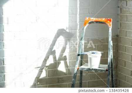 Interior wall painting works, stepladder and paint tools, home renovation, finishing, room decoration, professional wall finish process. Interior wall painting works, stepladder and paint tools, home renovation, finishing, room decoration, professional wall finish process. 138435426