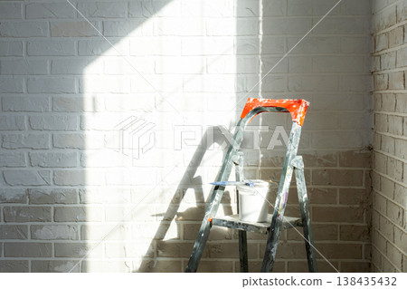 Interior wall repair, painting preparation, stepladder, paint supply, workspace for room improvement and home decor, construction finish. Interior wall repair, painting preparation, stepladder, paint supply, workspace for room improvement and home decor, construction finish. 138435432