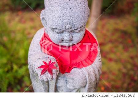Red maple leaf on hand of  Jizo statue in fall, Eikando temple, Kyoto 138435568