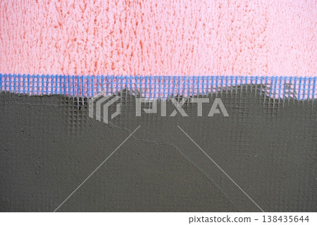 Plastering over mesh on outside wall, facade stucco, strengthening, protection for insulation, masonry works, external surface finishing, house construction. 138435644