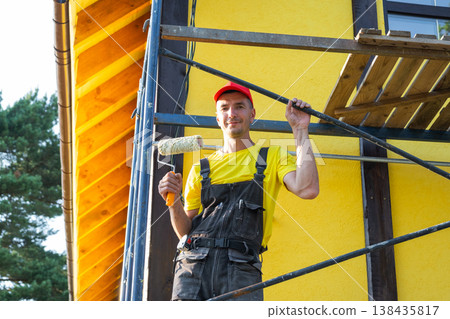 Portrait of construction worker in red cap with level tool, self-build home project, private handyman business, exterior repairs, do-it-yourself skills. Portrait of construction worker in red cap with level tool, self-build home project, private handyman business, exterior repairs, do-it-yourself skills. 138435817