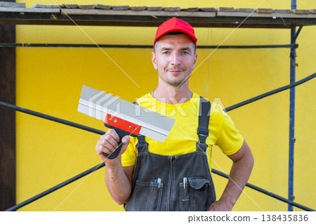 Private repairman portrait with wide putty knife, construction tools, at-home wall repair, private business, home building, DIY, carpentry, consultation. Private repairman portrait with wide putty knife, construction tools, at-home wall repair, private business, home building, DIY, carpentry, consultation. 138435836