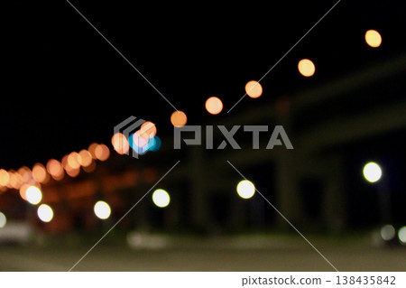 Particles of light floating in the darkness and the nighttime roadside scenery Particles of light floating in the darkness and the nighttime roadside scenery 138435842