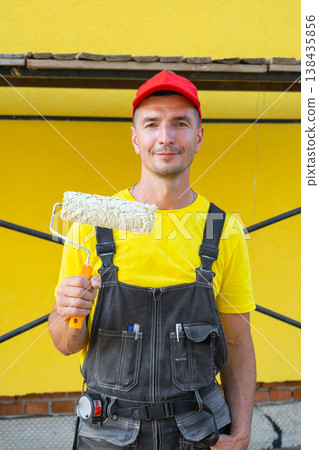 Portrait handyman with paint roller, ready for home painting, at-home repair project, private improvement business, tool kit, expert consultation, finishing works. 138435856