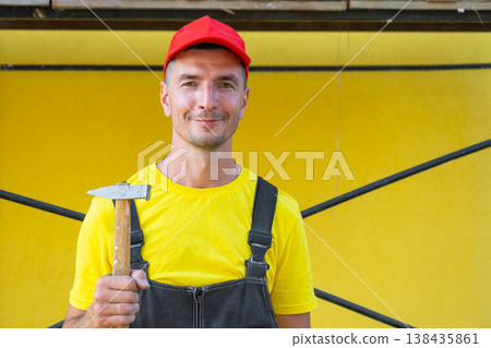 Home improvement specialist portrait with hammer, residential construction, nailing, framing, DIY techniques, private on-site repair business, handyman service. Home improvement specialist portrait with hammer, residential construction, nailing, framing, DIY techniques, private on-site repair business, handyman service. 138435861