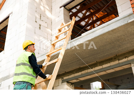 Construction professional organizes ladder and beams, prepares for next stage, wall structure setup, teamwork logistics, building project initiation, safety check. Construction professional organizes ladder and beams, prepares for next stage, wall structure setup, teamwork logistics, building project initiation, safety check. 138436027