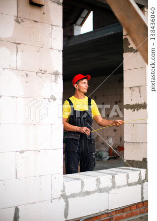 Window installer conducts precise opening measurement, construction stage, frame fit, wall segmentation layout, drywall and masonry dimensional check. Window installer conducts precise opening measurement, construction stage, frame fit, wall segmentation layout, drywall and masonry dimensional check. 138436040