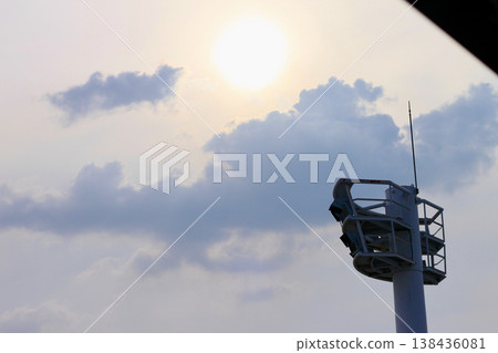 體育場的照明塔高聳入雲,在陰沉的天空下格外醒目,太陽就照在它們背後。 體育場的照明塔高聳入雲,在陰沉的天空下格外醒目,太陽就照在它們背後。 138436081
