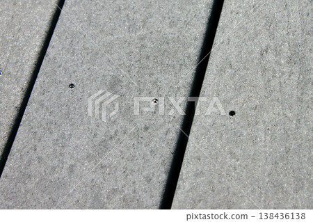 特寫鏡頭：一塊用螺絲固定的灰色樹脂木甲板。 138436138